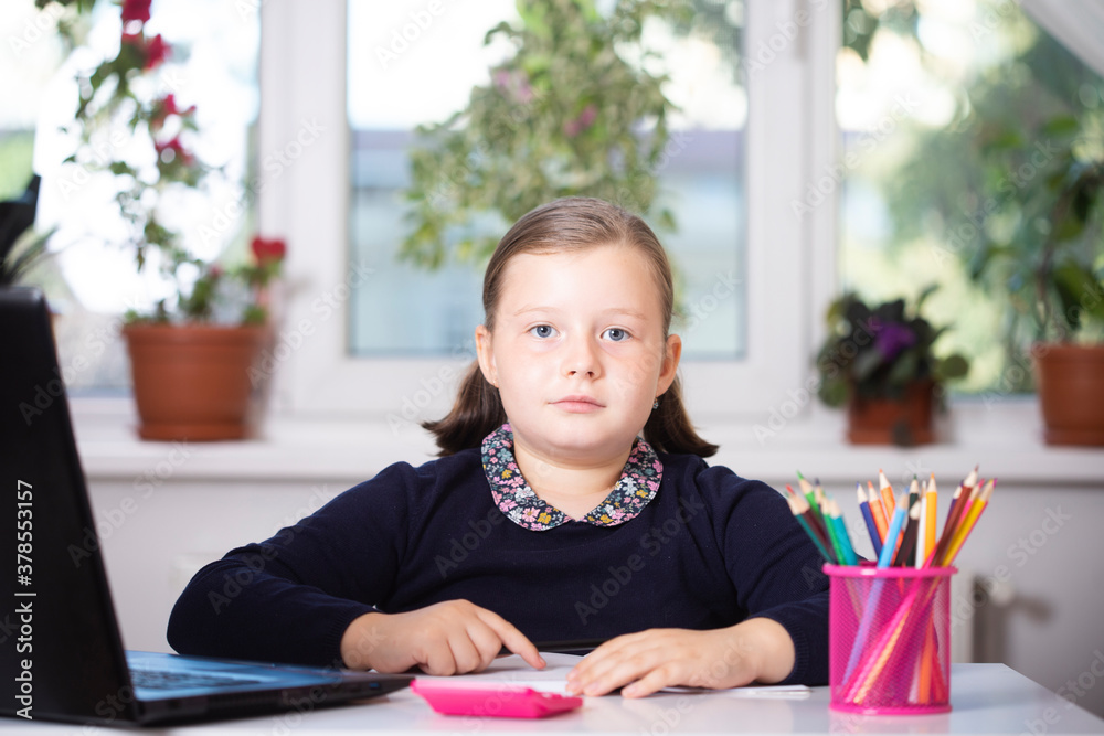 Study online with video call teacher. Young girl learn online and looking at laptop at home.Social distancing. Study online with video call teacher. Young girl learn online and looking at laptop at home.Social distancing.