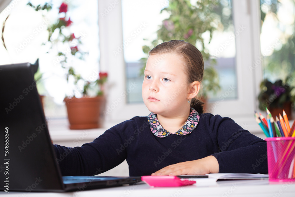 Study online with video call teacher. Young girl learn online and looking at laptop at home.Social distancing. Study online with video call teacher. Young girl learn online and looking at laptop at home.Social distancing.