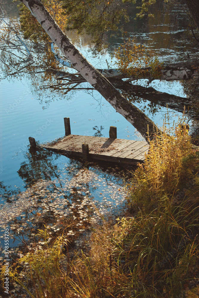 Wooden pier on the pond, autumn landscape