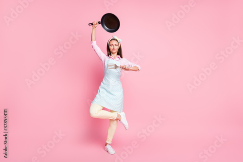 Full length body size view of her she nice attractive pretty focused housewife holding in hands kitchenware utensil posing meditating asana yoga zen isolated over pink pastel color background