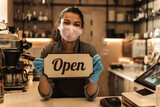 happy woman barista wearing medical mask showing open