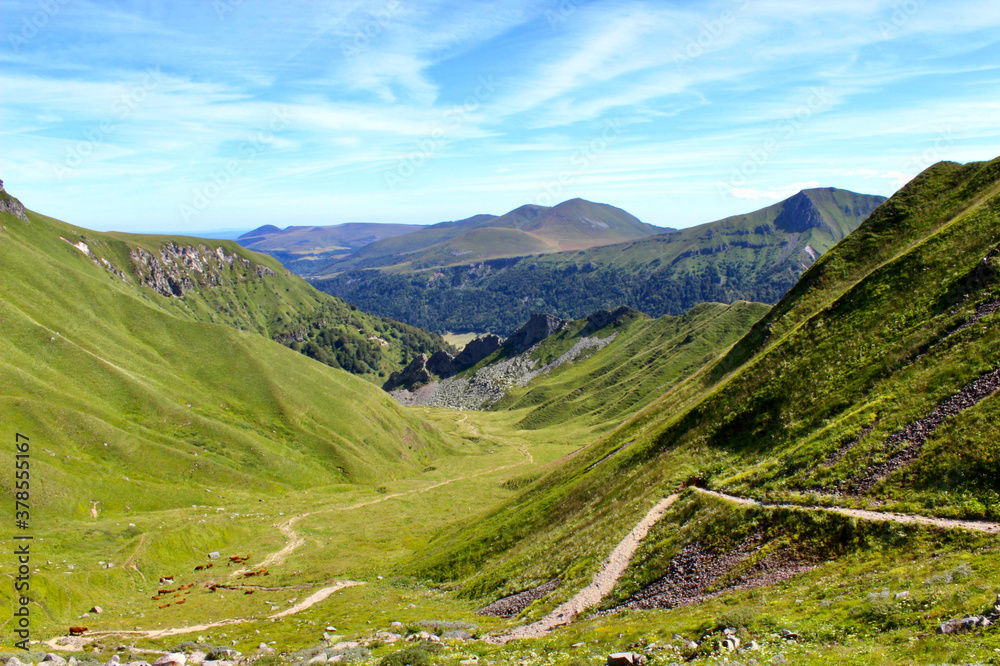 Vue sur la chaine des Puy en Auvergne pendant la descente du Puy de Sancy par les crêtes en randonnée