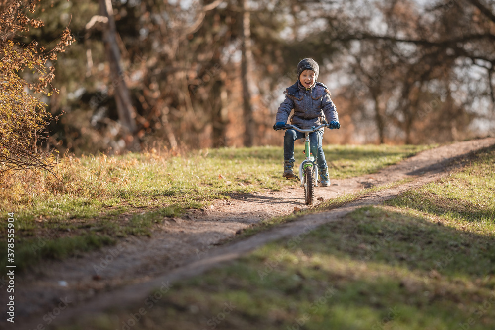 Six years old boy rides bicycle from the hill in the park. Six years old boy rides bicycle from the hill in the park.