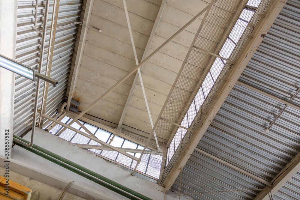 Ceiling made of old aluminum panels in the workshop of an industrial plant Ceiling made of old aluminum panels in the workshop of an industrial plant
