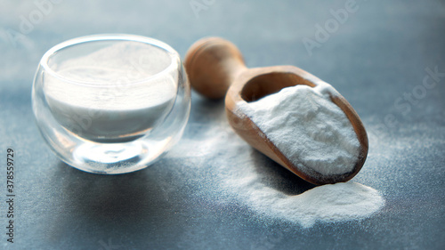 Glass bowl of baking soda. Spoonful of bicarbonate.