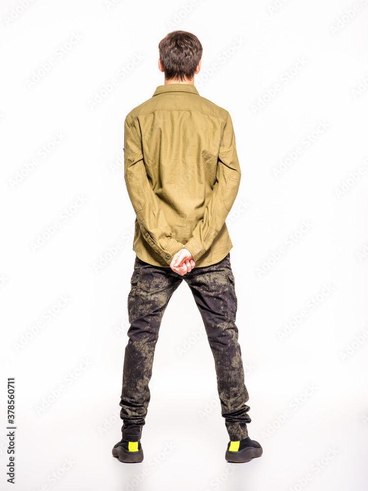 Back view of an young man in camouflage clothing. Rookie in army clothes. Teenager in khaki military clothing Back view of an young man in camouflage clothing. Rookie in army clothes. Teenager in khaki military clothing