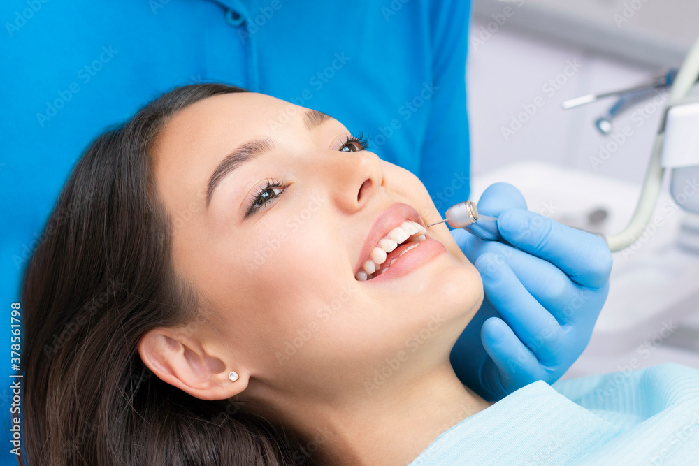 Attractive young woman in a dental clinic with a male dentist. Healthy teeth concept.