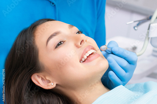 Attractive young woman in a dental clinic with a male dentist. Healthy teeth concept.