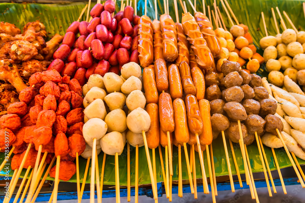 The fried sausage and Meatballs with bamboo, wood stick. Traditional Street Food Thailand.