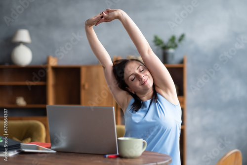 Caucasian woman performing a side stretching exercise for the spine working at home.