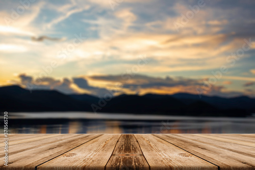 Showcase an old wooden table shelf on a beautiful sunset and blurred nature background.