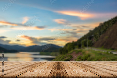 Showcase an old wooden table shelf on a beautiful sunset and blurred nature background.