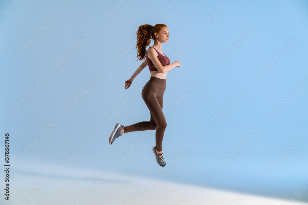 Photo of athletic focused sportswoman jumping while working out