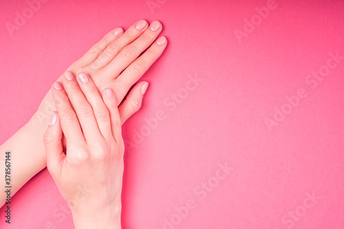 Beautiful female hands showing fresh cute manicure  skin and nail care concept  pink background copy space