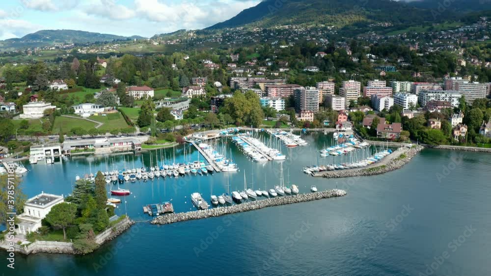 Yacht Club.Ferry in Switzerland.Cars and bus driving on the shoreline road along the Lake Geneva.Montreux city and mountains on the background. Yacht Club.Ferry in Switzerland.Cars and bus driving on the shoreline road along the Lake Geneva.Montreux city and mountains on the background.