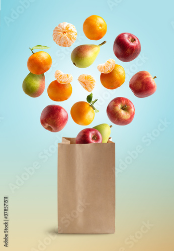 Fototapeta Naklejka Na Ścianę i Meble -  Fresh fruits flying out of a recyclable paper bag