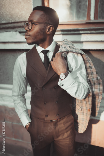 Stylish man shows holding his jacket on his shoulder