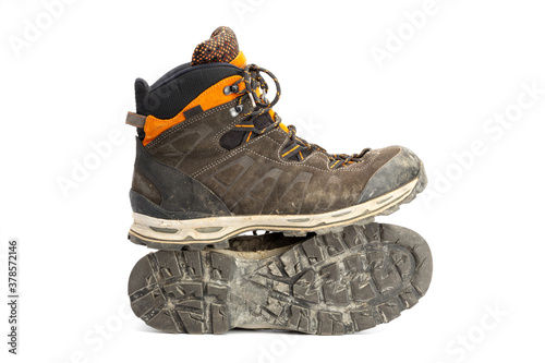 Pair of dirty brown/orange men's hiking boots with white background. Side view, landscape format.