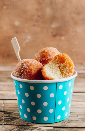 Cottage cheese donuts in a light blue paper cup
