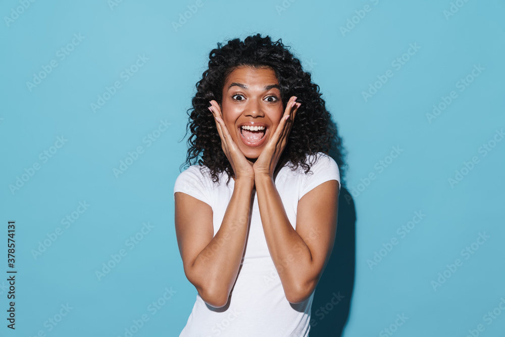Image of excited african american woman expressing surprise at camera