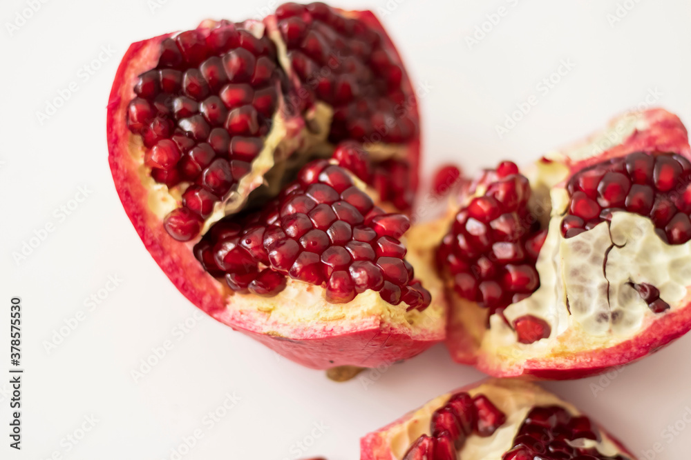 Pomegranate fruit on a white background and mint leaves Pomegranate fruit on a white background and mint leaves