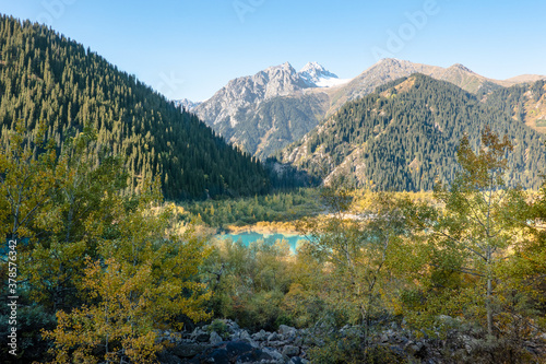 Panorama of Tien Shan mountains, Issyk lake and autumn forest. Kazakhstan