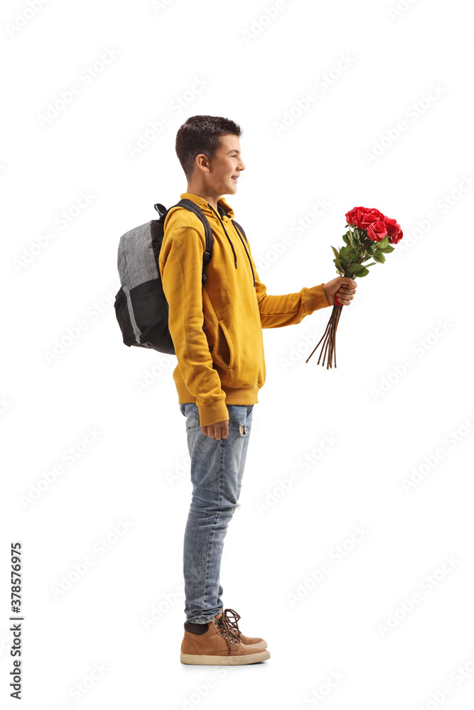 Full length profile shot of a male teenage student holding a bunch of red roses Full length profile shot of a male teenage student holding a bunch of red roses