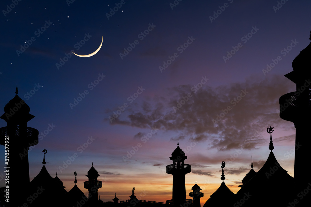 silhouette of the dome mosques and crescent moon on dusk sky