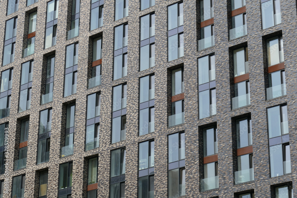 Exterior of a high-rise multi-story apartment building - facade, windows and balconies.