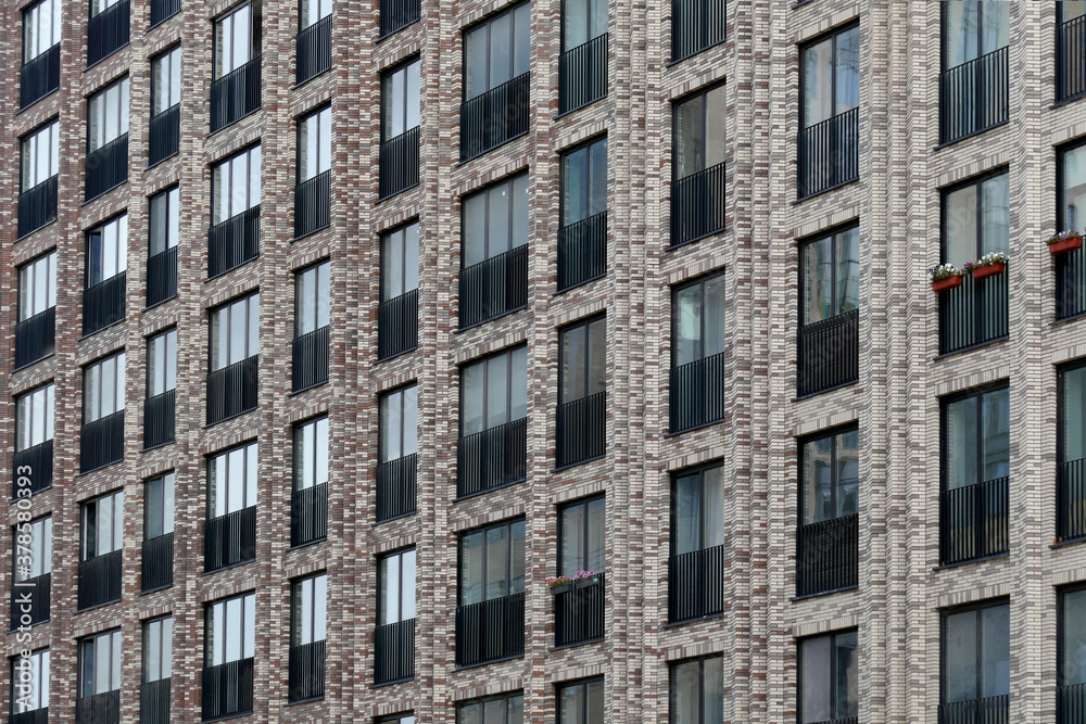Exterior of a high-rise multi-story apartment building - facade, windows and balconies.