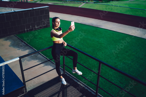 Female runner taking selfie on smartphone © BullRun