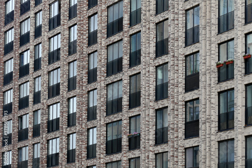 Exterior of a high-rise multi-story apartment building - facade, windows and balconies.