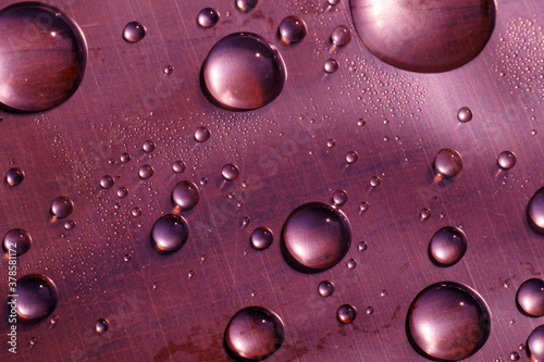 Fotografia Surface tension. Water drops on the surface covered with foil.