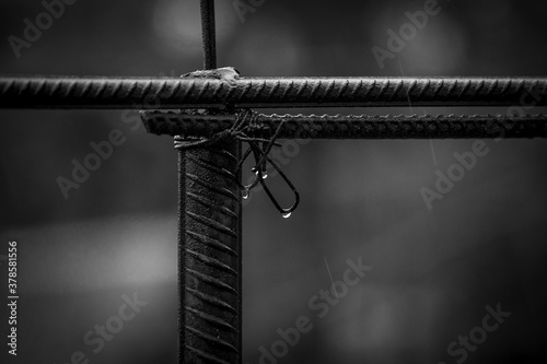 Metal fittings connected with wire. Rainy weather with water drops. Black and white photo.