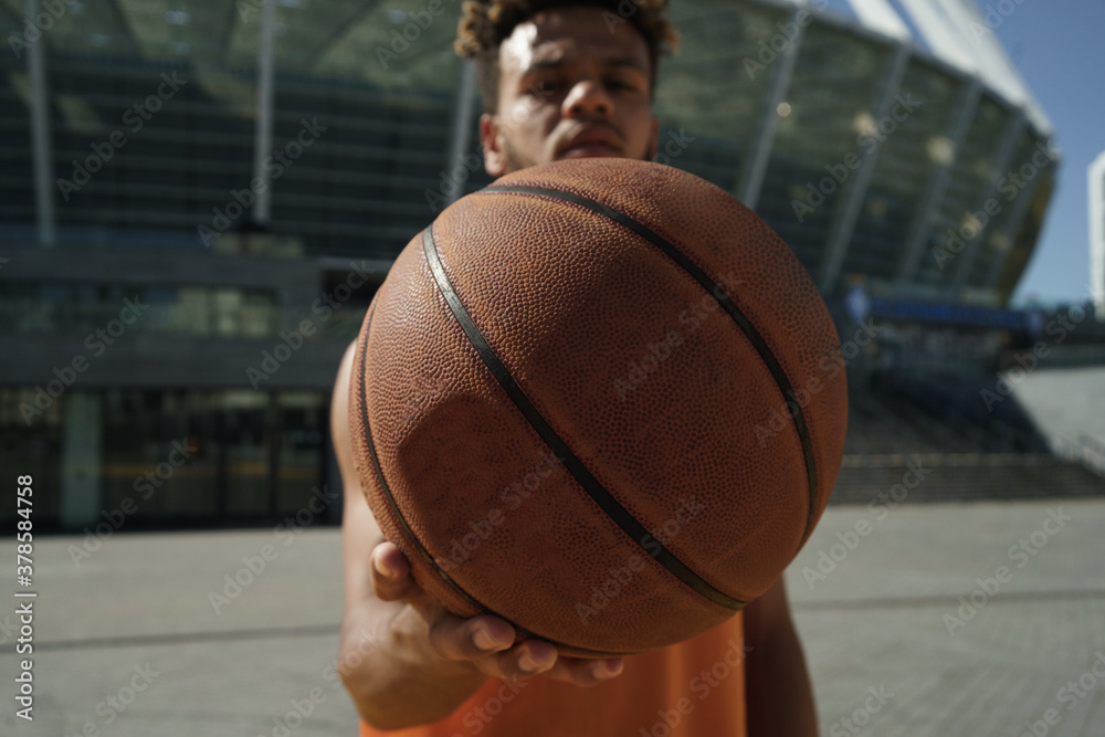 Image of african american guy posing with basketball on sports ground Image of african american guy posing with basketball on sports ground