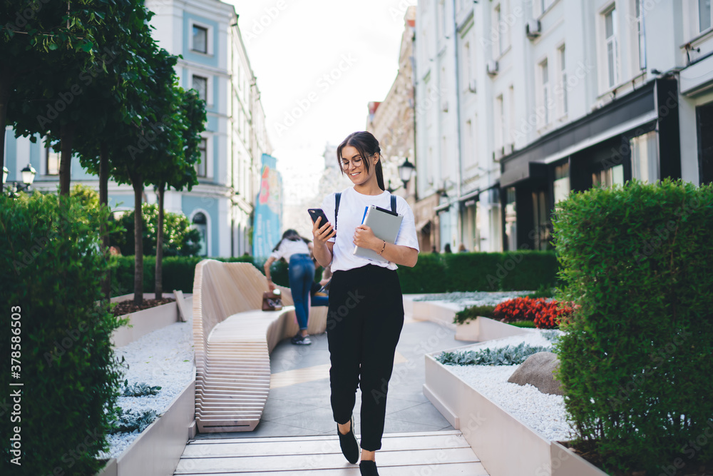 Happy young woman browsing smartphone on street Happy young woman browsing smartphone on street