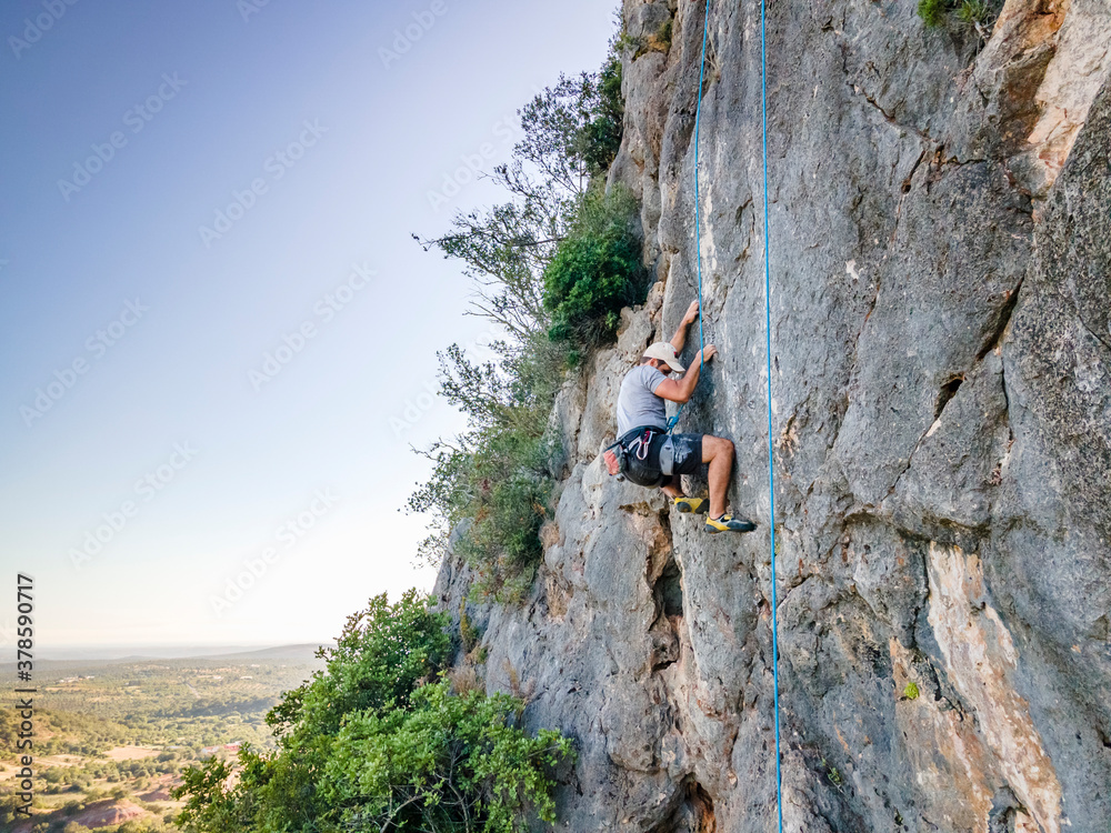 Climber with harness on huge rock