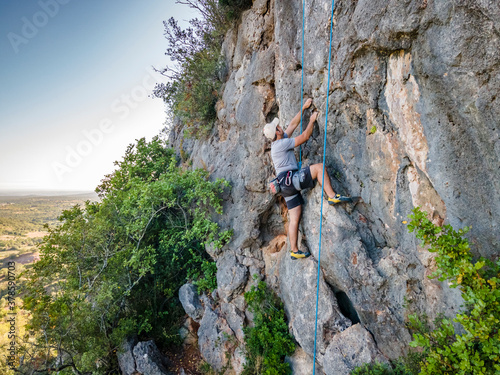 Climber with harness on huge rock