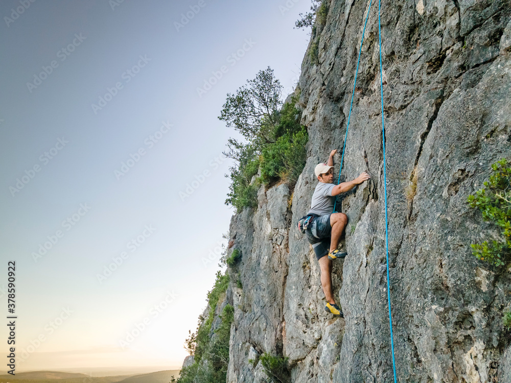 Climber with harness on huge rock