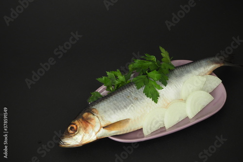 Herring whole, undivided with onion and parsley, close-up. Fish photo