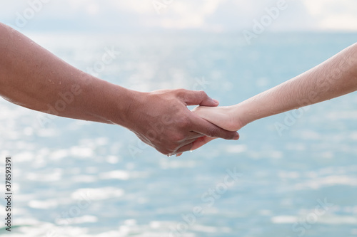 Close up of love couple holding hands on the sea beach, Nature of ocean background with sunlight on the summertime, Travel honeymoon couples and Sweet valentine concept. © GAYSORN