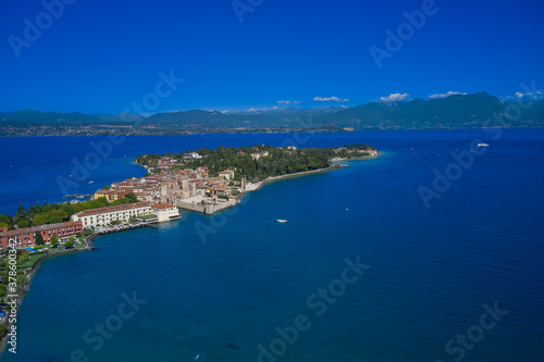 An ancient village on southern Garda Lake. Aerial view on Sirmione sul Garda. Italy, Lombardy. View by Drone. Aerial view at high altitude. Rocca Scaligera Castle in Sirmione. © Berg