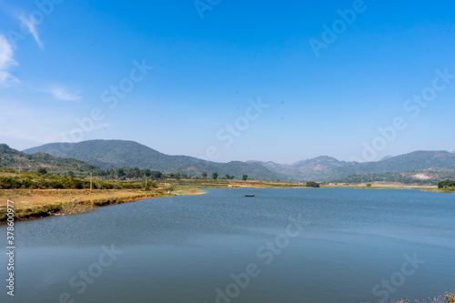 Awesome view of small lake near a greenery mountain background. 