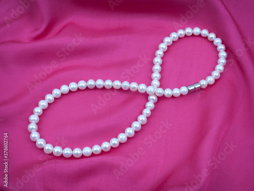 Pearl necklace on silk textured satin material