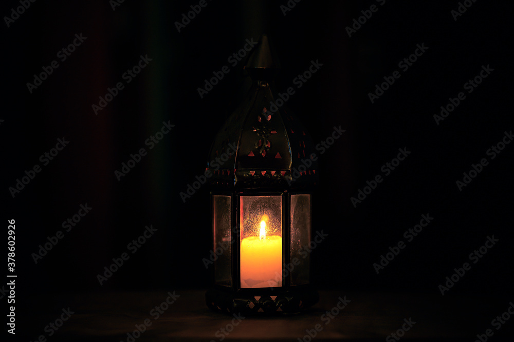 Night scene with vintage lamp. Candle, magic, witchcraft and mysticism. Warm glow in the dark