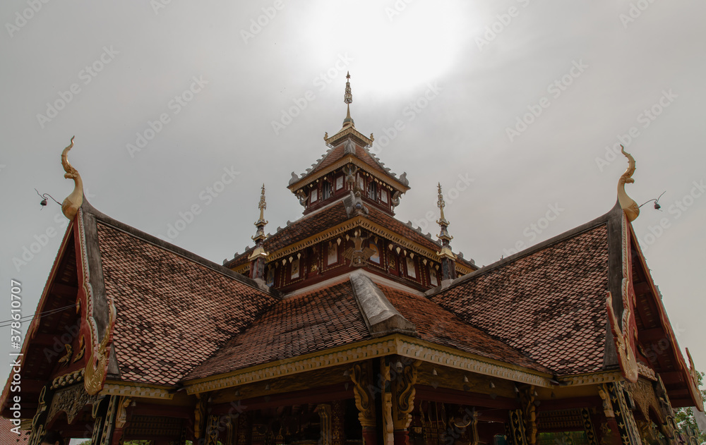 Ancient wooden roof on Buddhist temple in Wat Pratu Pong at Lampang Province. Beautiful temple built in a mix of Lanna and Burmese Shan styles. Selective focus.