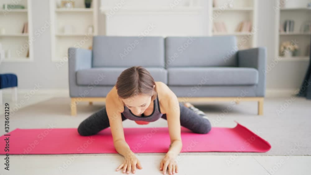 Fit Pregnant Girl Is doing Sports Exercises Sitting On Yoga Mat On livingroom Floor Fit Pregnant Girl Is doing Sports Exercises Sitting On Yoga Mat On livingroom Floor