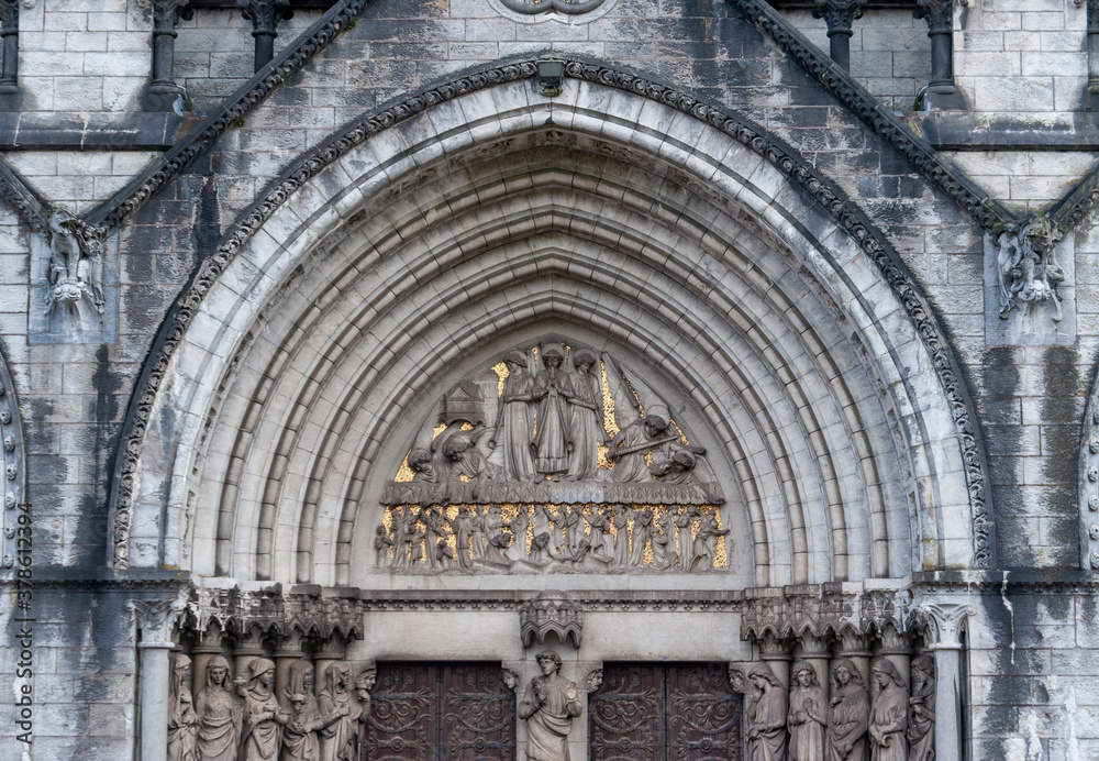 Sculptures above the portal, on the façade of St Finn Barre's Cathedral in Cork, Ireland, built in the 19th  century in Gothic Revival style. 