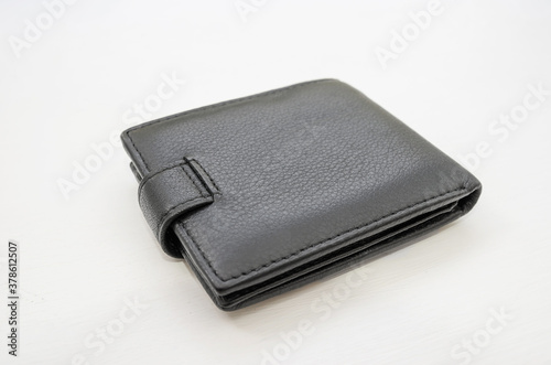 black men's wallet on a white wooden table.