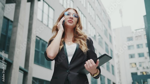 Happy successful businesswoman stand on street speaking on phone near business center. Internet chatting. Digital woman. Worker. Corporate. Entrepreneur. Online. Stylish. Slow motion.